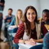 Happy female student learning in the classroom and looking at camera. Happy female student learning in the classroom and looking at camera.